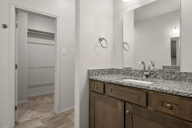 a bathroom with a granite countertop sink and a mirror