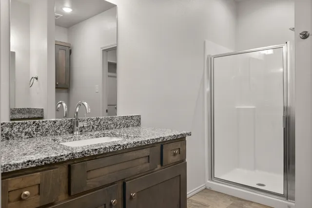 a bathroom with a granite countertop sink and a mirror