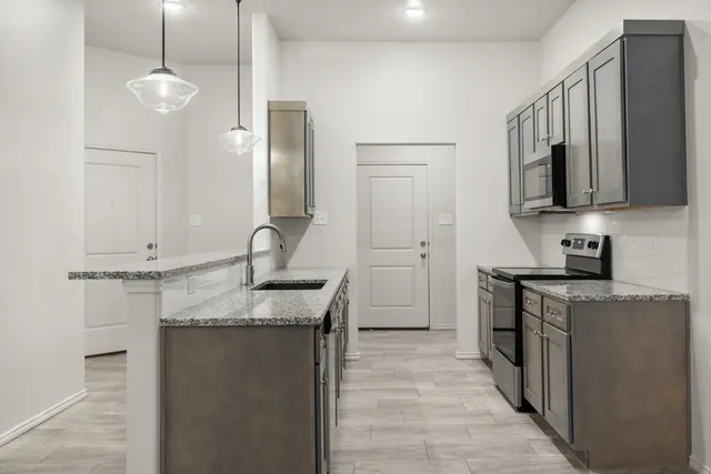 a kitchen with stainless steel appliances granite countertop a sink stove and refrigerator