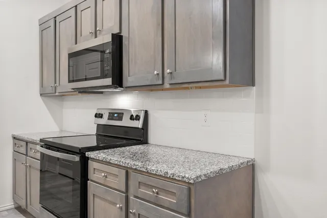 a kitchen with granite countertop cabinets stainless steel appliances and a sink