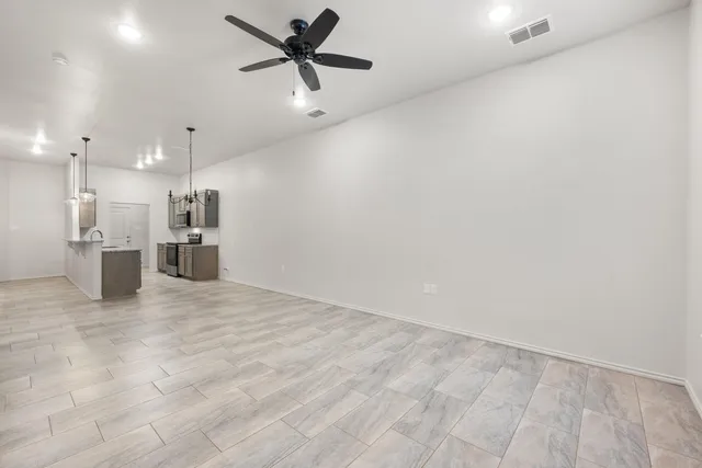 an empty room with cabinet and stainless steel appliances
