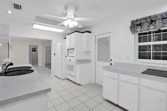 a spacious bathroom with a double vanity sink a mirror a window and a bathtub