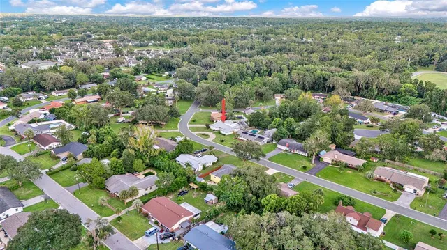 an aerial view of residential houses with outdoor space and trees