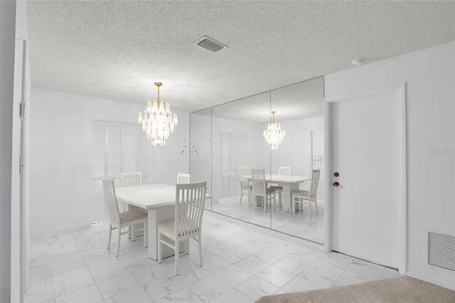 a view of a dining room with furniture and chandelier