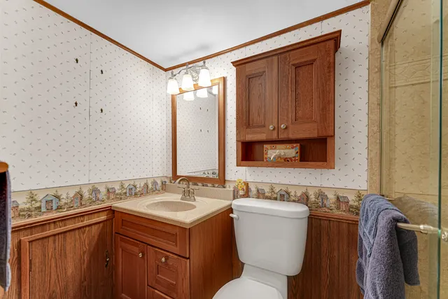 a bathroom with a toilet sink and mirror
