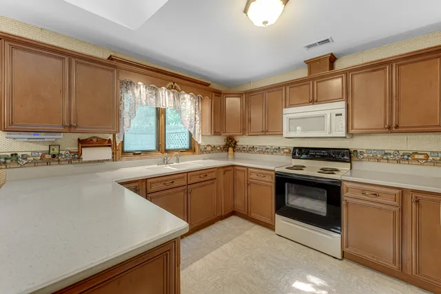 a kitchen with stainless steel appliances granite countertop a stove a sink and a microwave