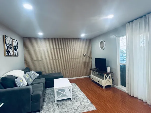 a living room with furniture and a wooden floor
