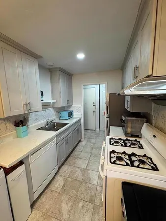 a kitchen with a sink a stove and refrigerator