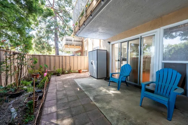 a view of patio with a table and chairs and a barbeque