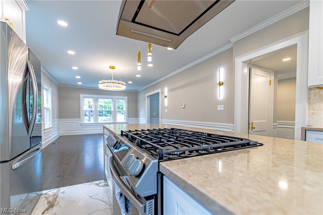 2923 Huntington Road Cleveland, OH 44120 - Photo 14 of 35 Kitchen with a chandelier, white cabinets, decorative light fixtures, dark hardwood / wood-style flooring, and appliances with stainless steel finishes