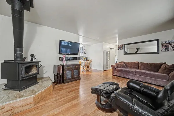 a living room with furniture a flat screen tv and kitchen view