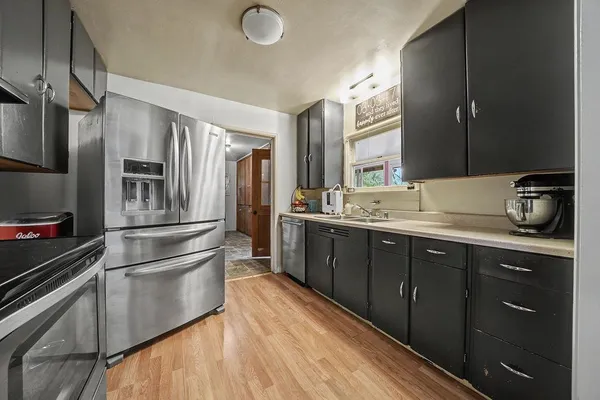 a kitchen with stainless steel appliances granite countertop a refrigerator and a sink