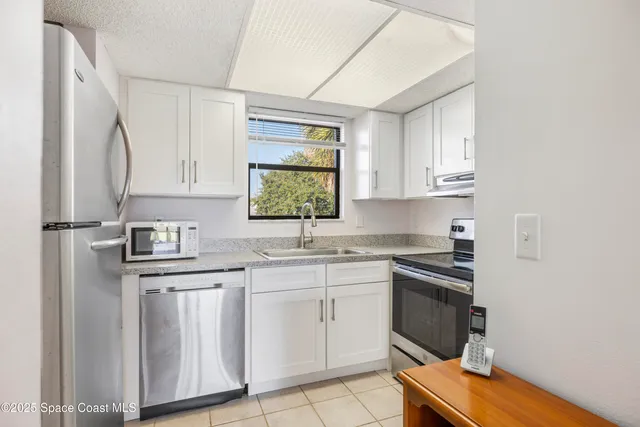 a kitchen with cabinets appliances a sink and a window