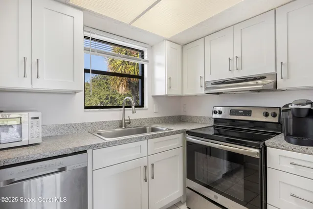 a kitchen with appliances cabinets and a window