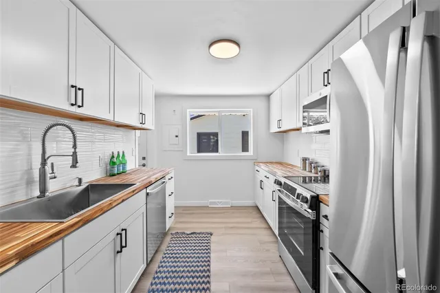 a kitchen with granite countertop a refrigerator and a sink
