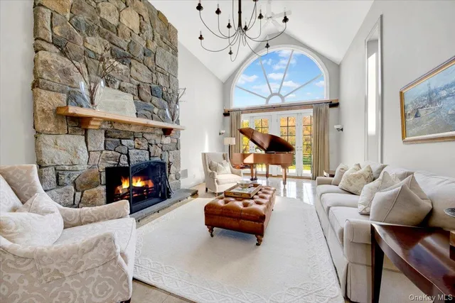 a living room with furniture a fireplace and a chandelier