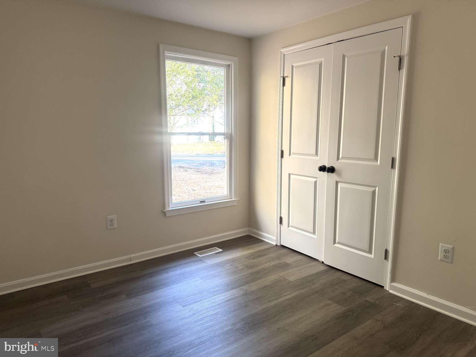 905 Crystal Rock Road Lusby, MD 20657 - Photo 12 of 22 an empty room with wooden floor and windows