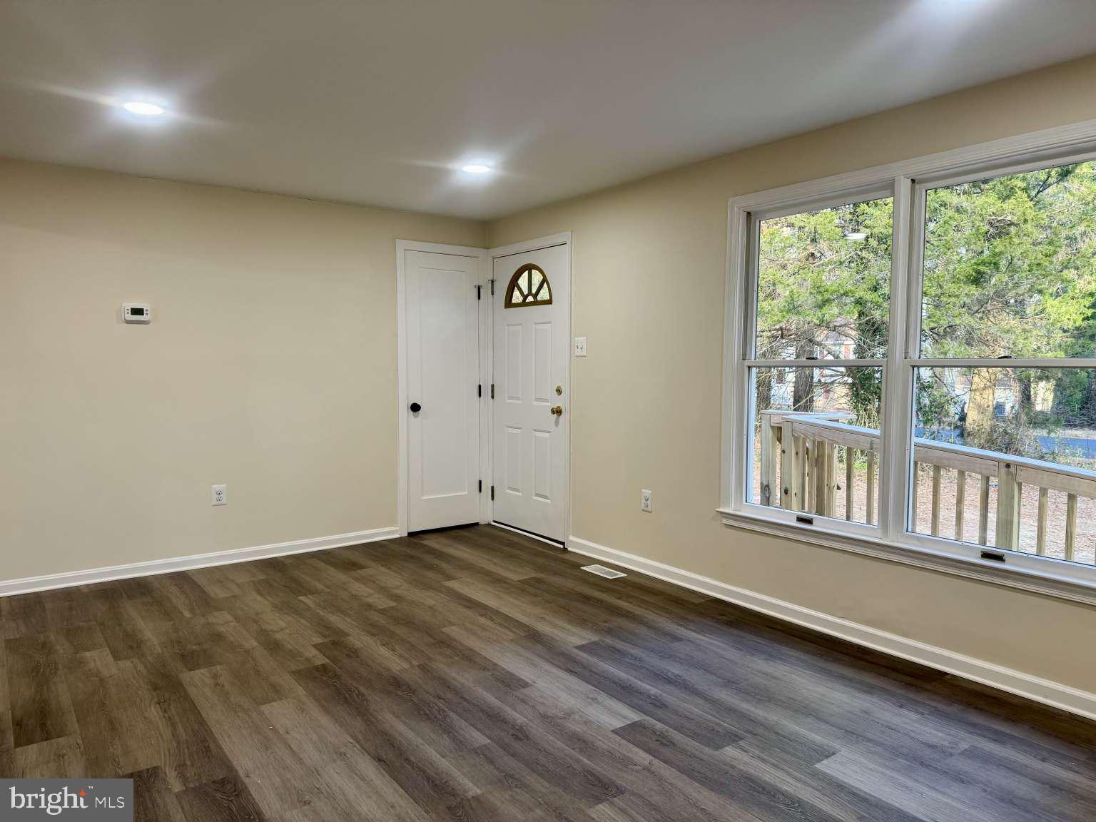 905 Crystal Rock Road Lusby, MD 20657 - Photo 13 of 22 an empty room with wooden floor and windows