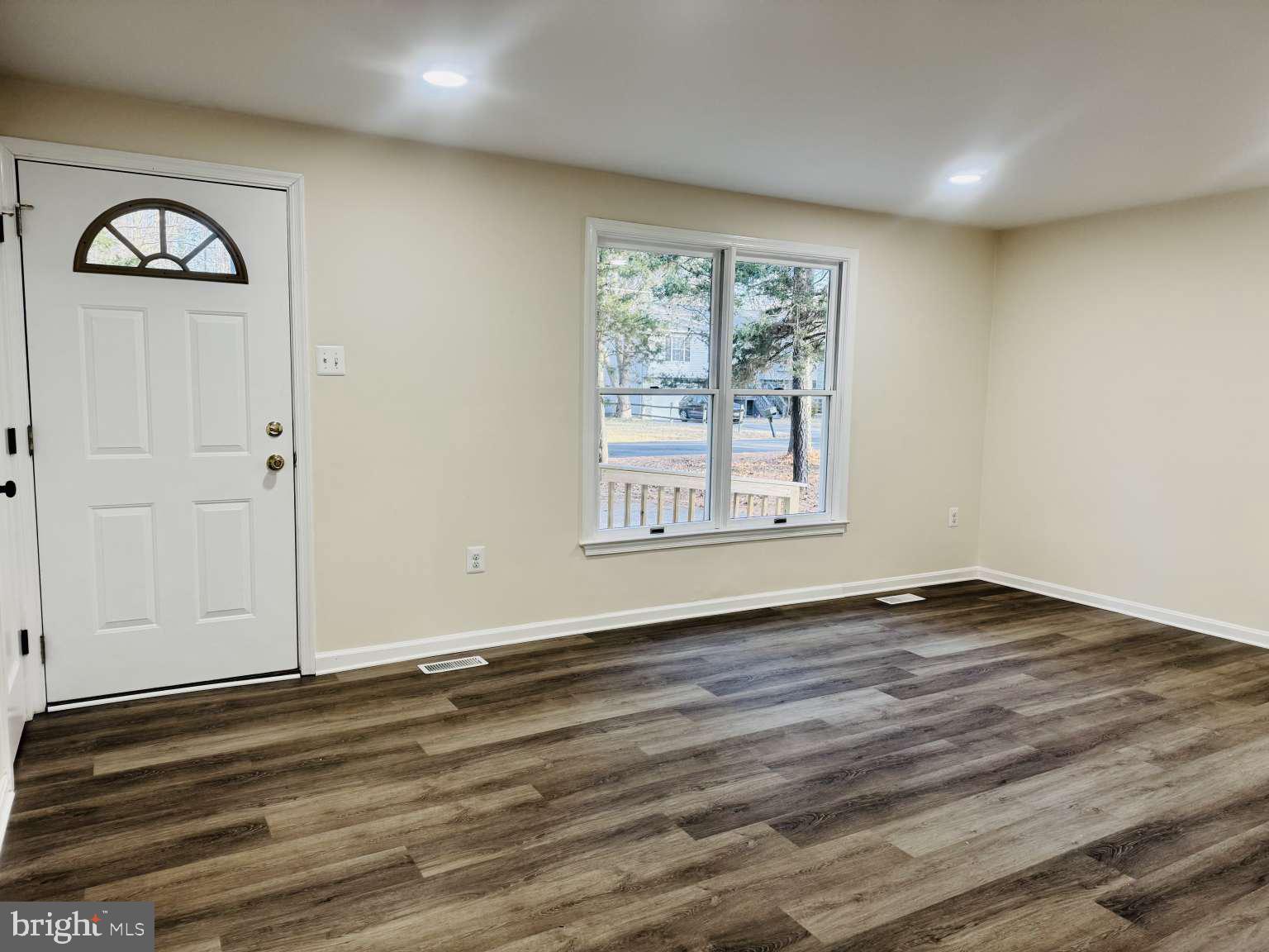 905 Crystal Rock Road Lusby, MD 20657 - Photo 3 of 22 an empty room with wooden floor and windows