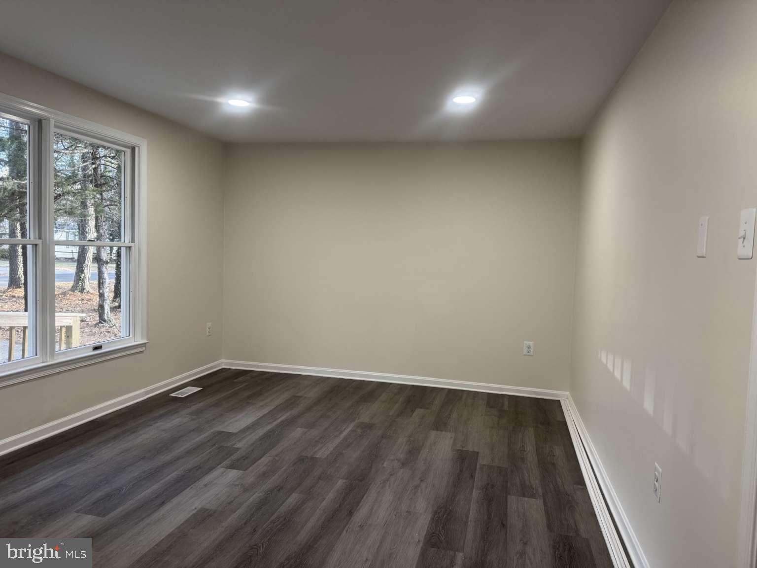 905 Crystal Rock Road Lusby, MD 20657 - Photo 5 of 22 a view of an empty room with wooden floor and a window