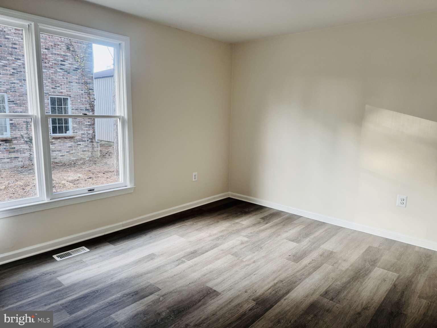 905 Crystal Rock Road Lusby, MD 20657 - Photo 9 of 22 a view of an empty room with wooden floor and a window