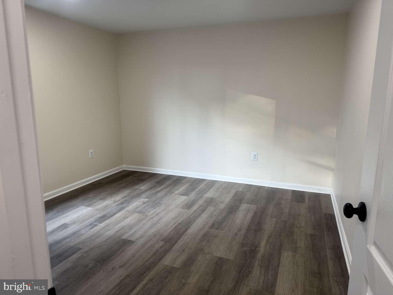 905 Crystal Rock Road Lusby, MD 20657 - Photo 10 of 22 a view of an empty room with wooden floor and a window