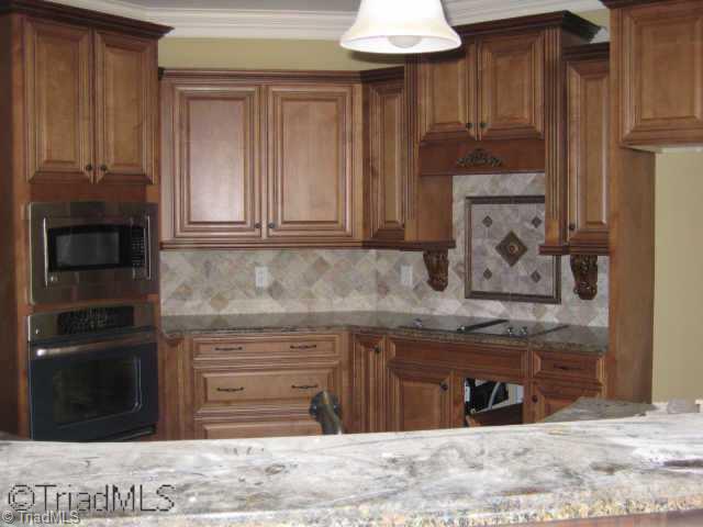 5809 Bison Drive Oak Ridge, NC 27310 - Photo 3 of 9 Other. Kit. w/custom cabinets & backsplash open to breadfast nook and great room