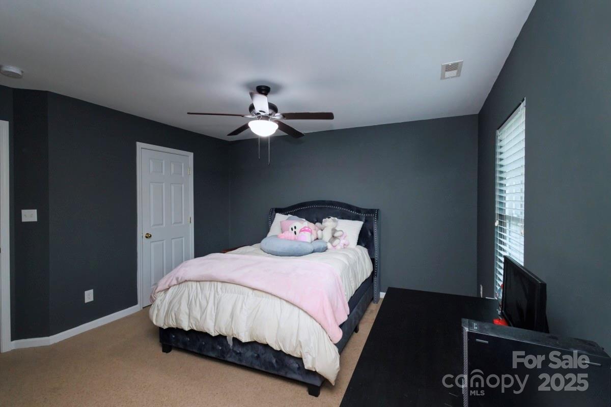 1457 Prestbury Road Northwest Concord, NC 28027 - Photo 12 of 19 a bedroom with a bed and a chandelier