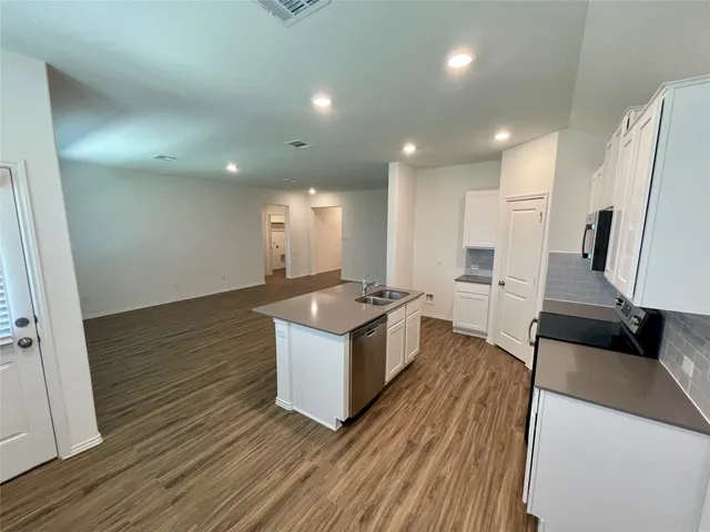 an open kitchen with a sink and refrigerator