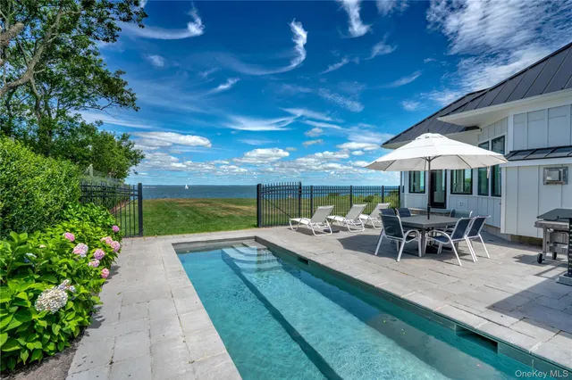 a view of a patio with furniture and table under an umbrella