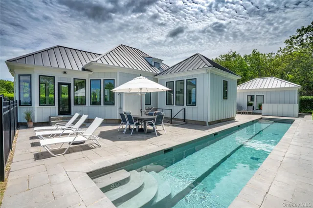 a view of a patio with a dining table and chairs under an umbrella