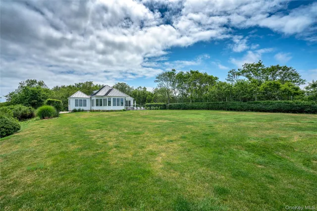 a front view of a house with yard and green space