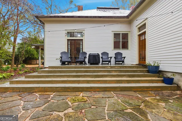 a backyard of a house with barbeque oven table and chairs