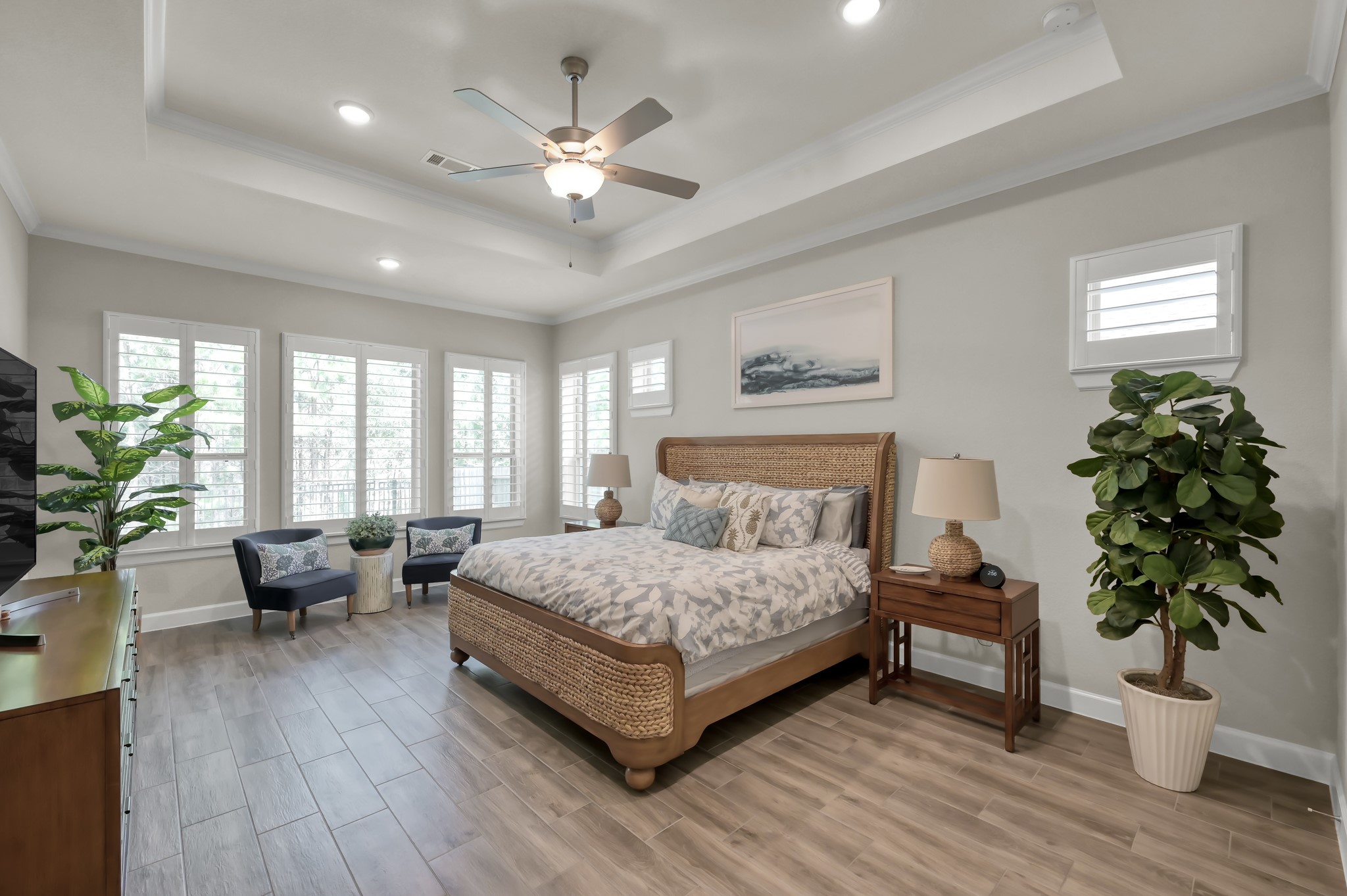 334 Torrey Bloom Loop Conroe, TX 77304 - Photo 25 of 47 Spacious primary suite with tray ceiling, abundant natural light, and sitting area—offering a peaceful retreat with serene backyard views.