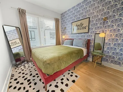 a bedroom with a bed and a lamp on the dresser