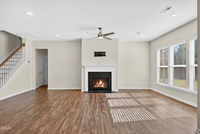 a view of an empty room with a fireplace and a window