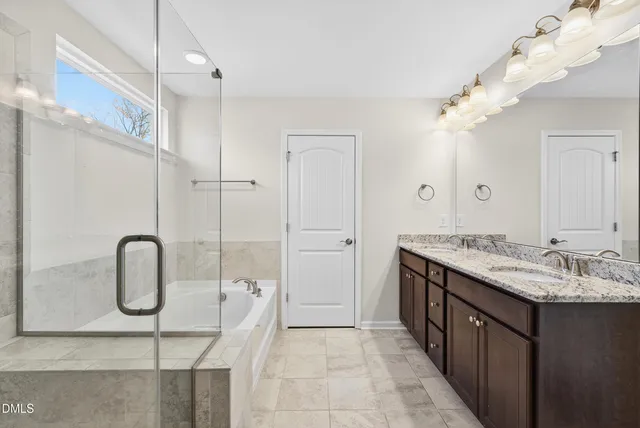 a bathroom with a double vanity sink mirror and shower