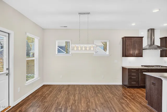 a view of kitchen with wooden floor and electronic appliances