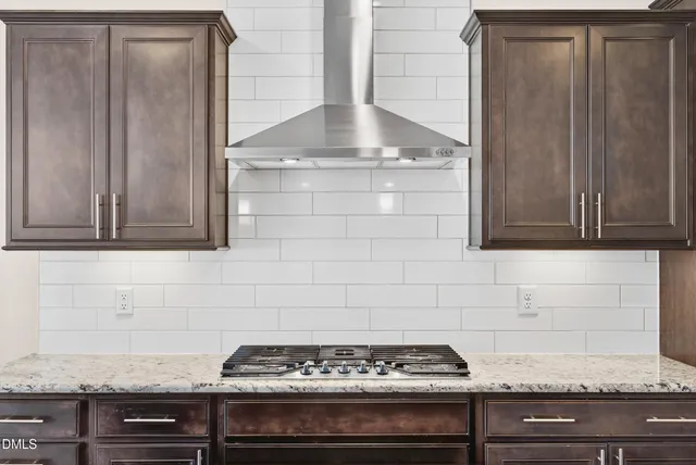 a kitchen with granite countertop a stove and cabinets