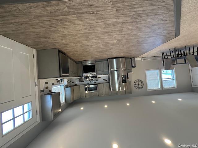 884 Beach Street Lindenhurst, NY 11757 - Photo 3 of 9 a large kitchen with a large counter top stainless steel appliances a window and wooden floor