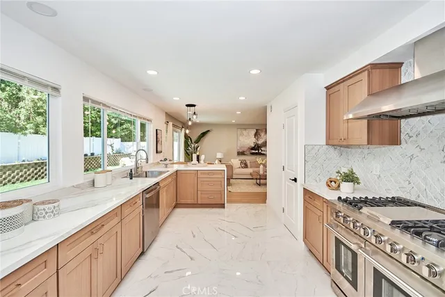a large kitchen with stainless steel appliances granite countertop a lot of counter space and wooden floors
