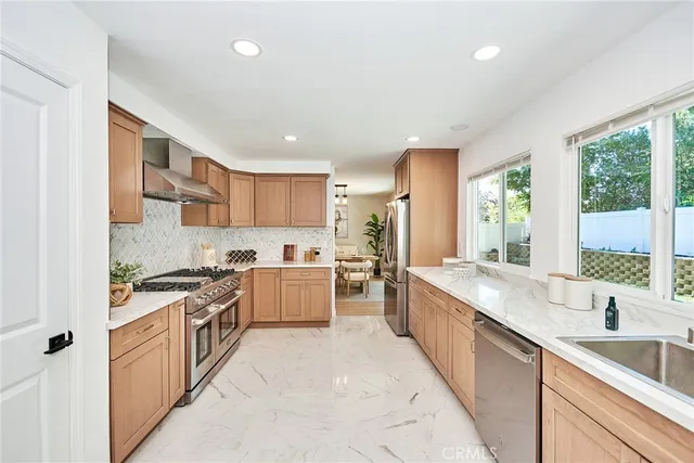 a large kitchen with stainless steel appliances granite countertop a lot of counter space and a sink