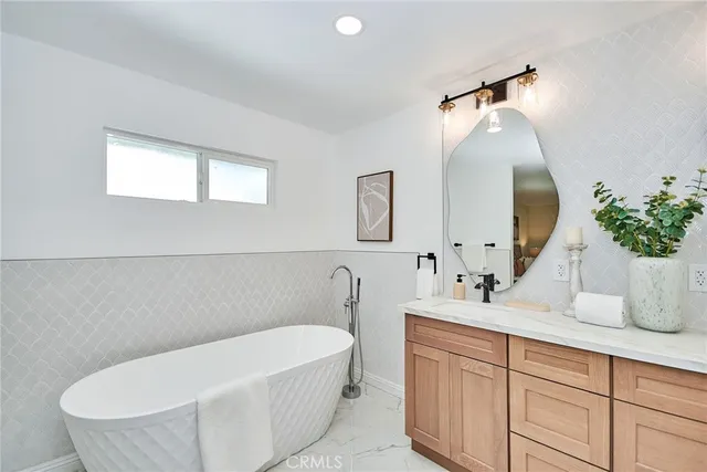 a bathroom with a tub sink and mirror