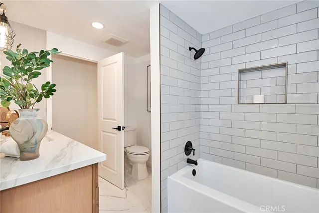 a bathroom with a granite countertop sink and a bathtub