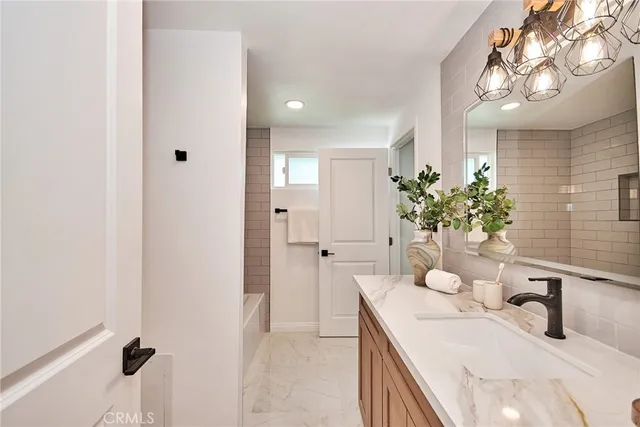 a bathroom with a granite countertop sink a mirror and a shower