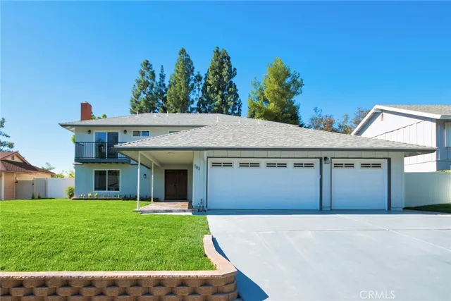a front view of a house with a garden and yard