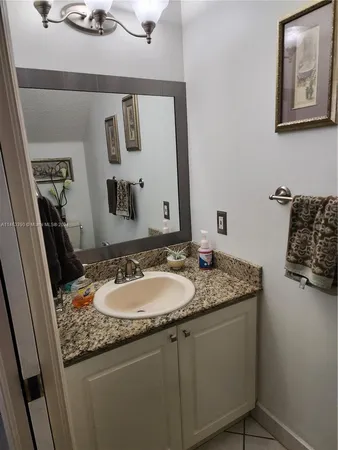 a bathroom with a granite countertop sink and a mirror