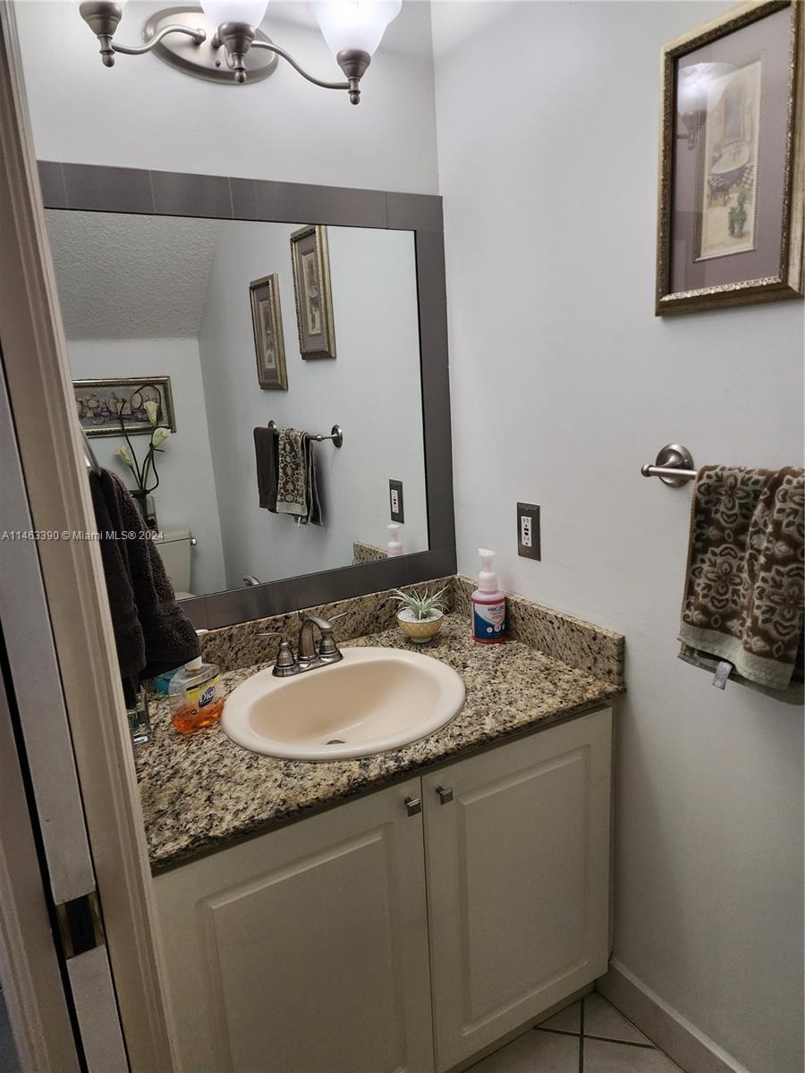 8260 Northwest 10th Street, Unit 2 Miami, FL 33126 - Photo 7 of 9 a bathroom with a granite countertop sink and a mirror