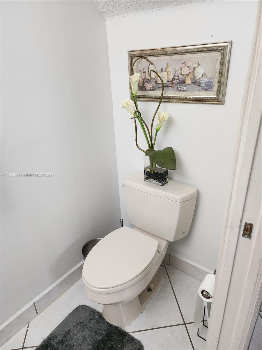 8260 Northwest 10th Street, Unit 2 Miami, FL 33126 - Photo 8 of 9 a white toilet sitting next to a bathroom sink