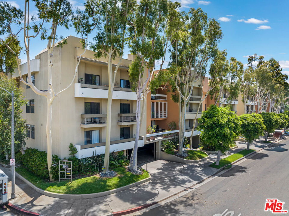 750 North Kings Road, Unit 204 Los Angeles, CA 90069 - Photo 1 of 23 a view of a brick house with a yard and plants